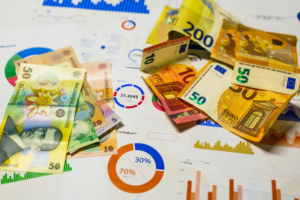 pexels-photo-29899905-29899905 Colorful Euro and Romanian Lei banknotes on top of financial charts, symbolizing currency exchange and economic analysis.